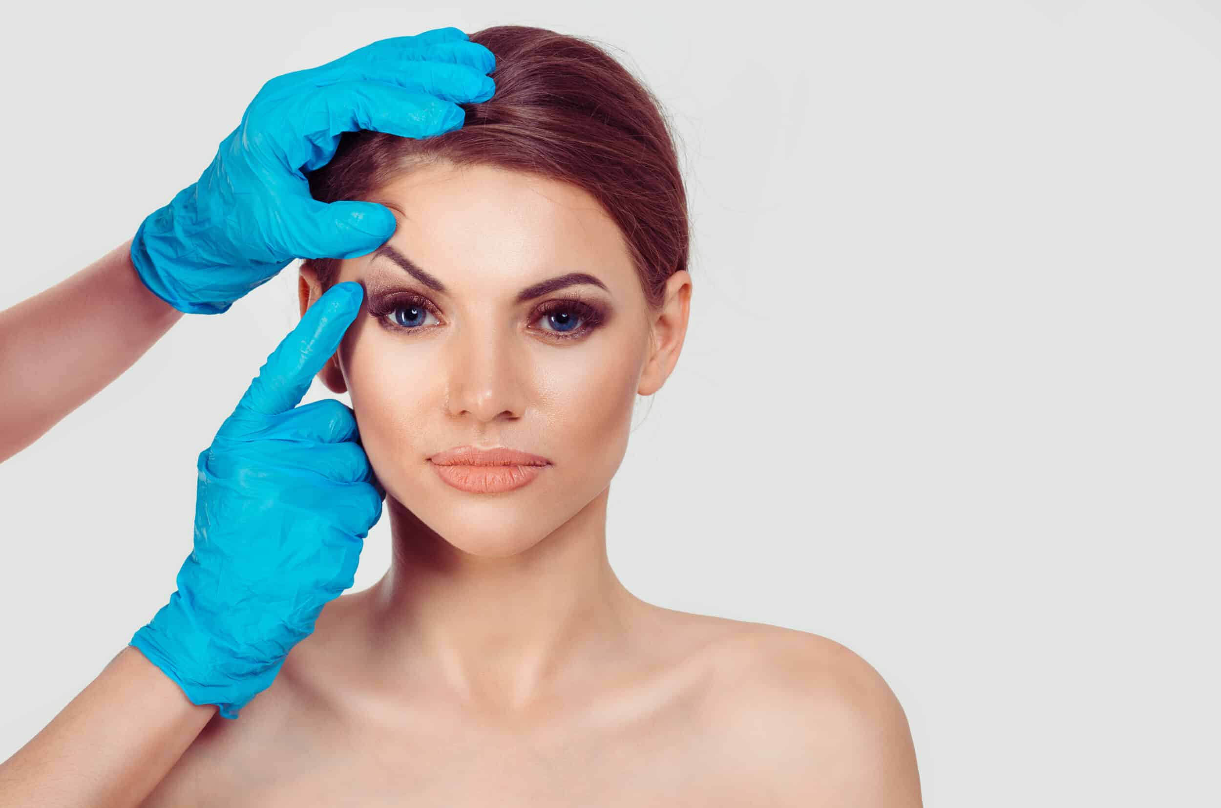 Doctor examining a patients face and eyebrows before their endoscopic brow lift