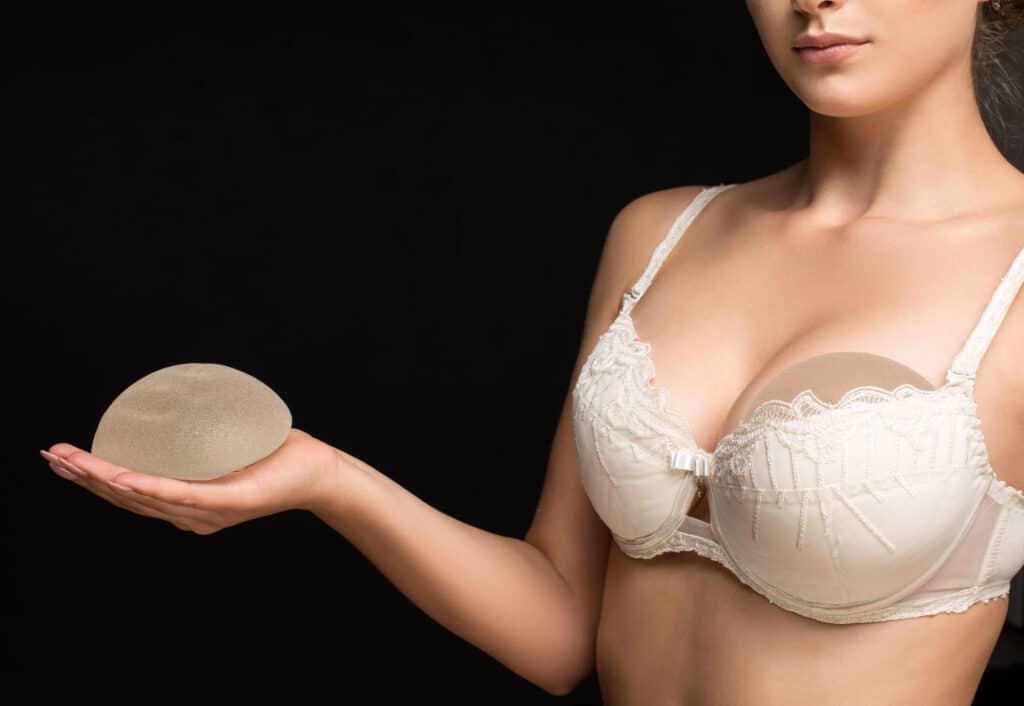 Woman trying out and looking at breast implant options for her breast implant revision