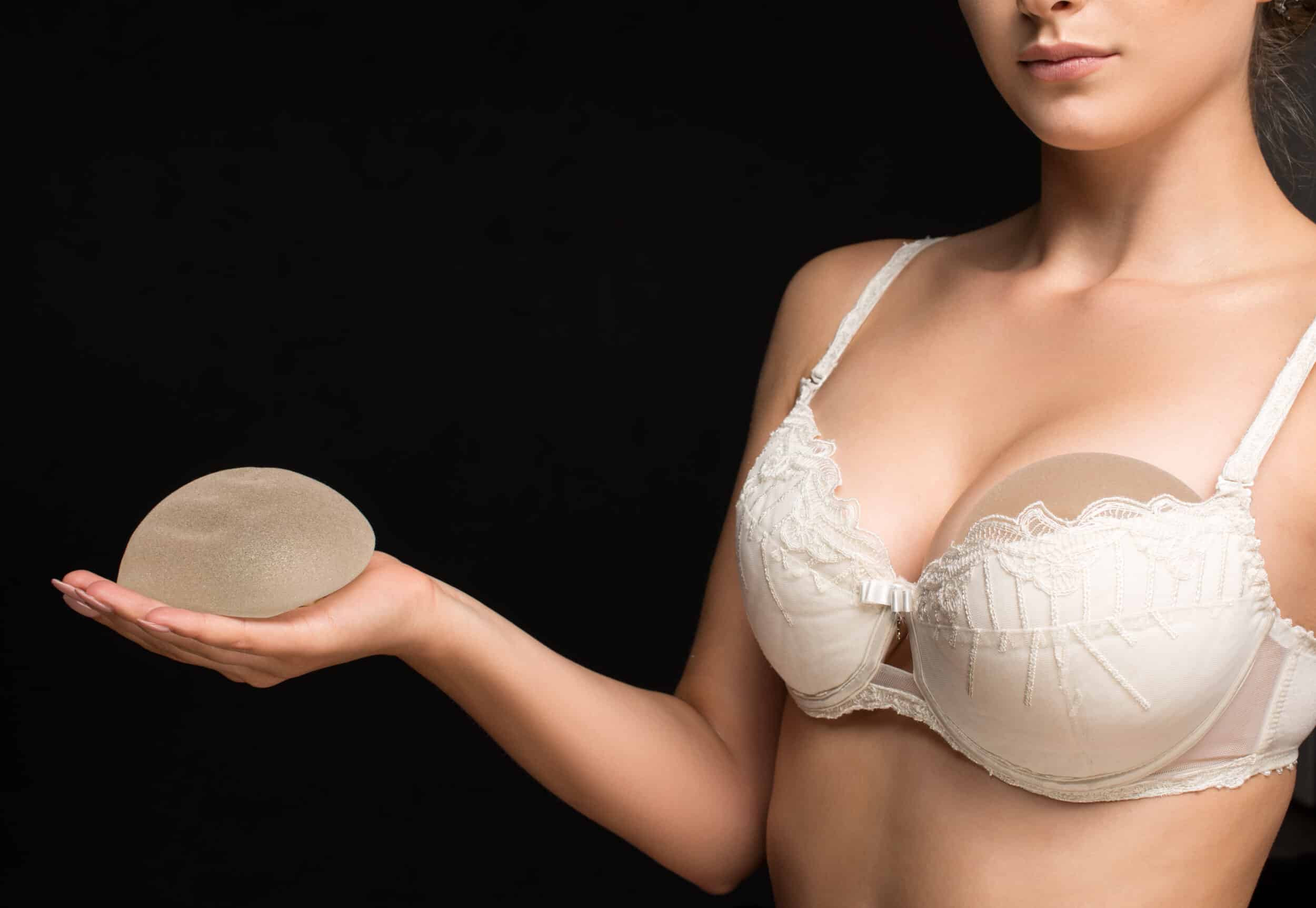 Woman trying out and looking at breast implant options for her breast implant revision
